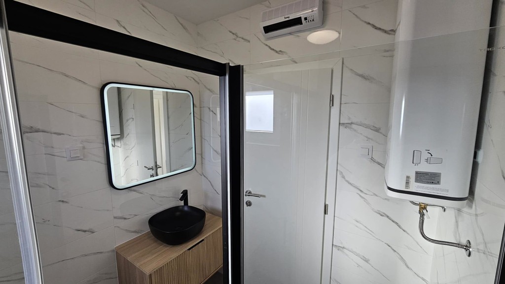 Salle de bains avec chauffe-eau et lavabo