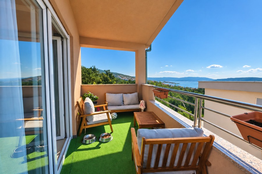 Balcon avec mobilier en bois et vue sur la mer