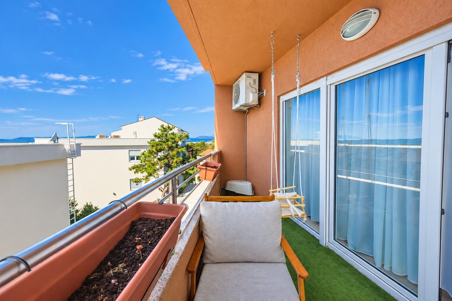 Balcon avec fauteuil et porte vitrée