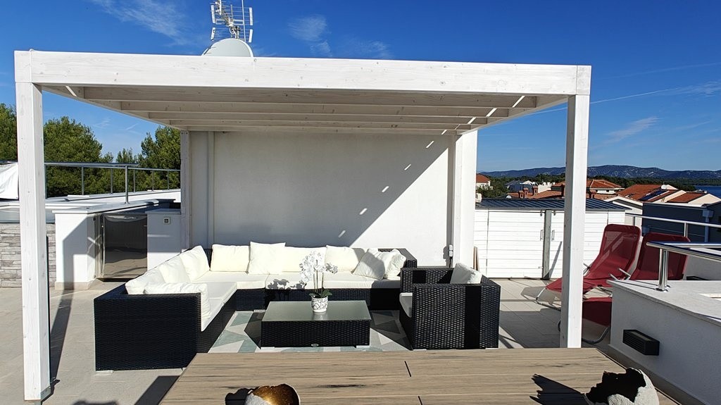 Coin salon sous la pergola sur la terrasse sur le toit