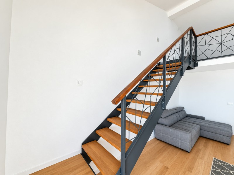 Escalier à rampe métallique menant à la mezzanine