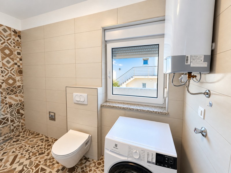 Salle de bain avec WC et lave-linge