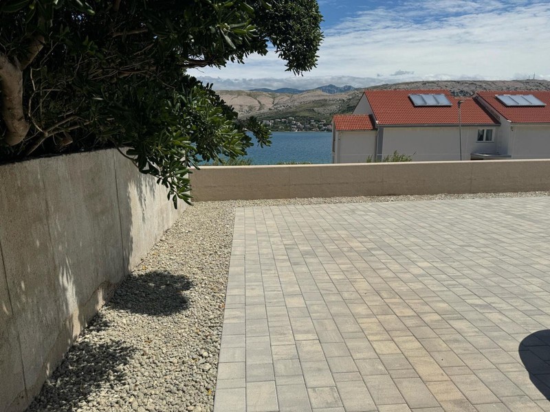 Cour pavée avec muret et vue sur la mer