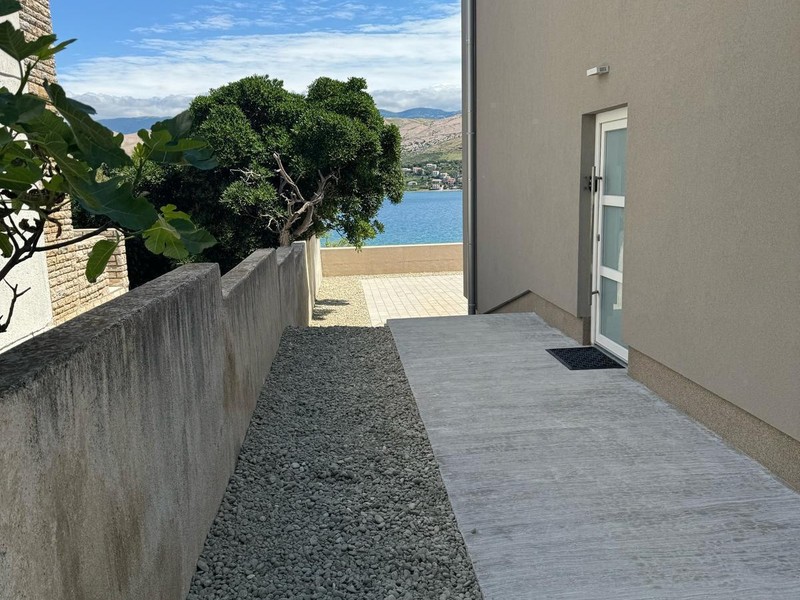 Chemin latéral le long de la maison avec vue sur la mer