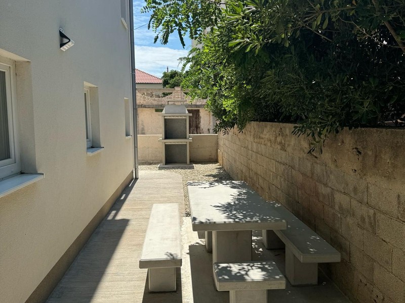 Table de jardin avec bancs à côté de la maison