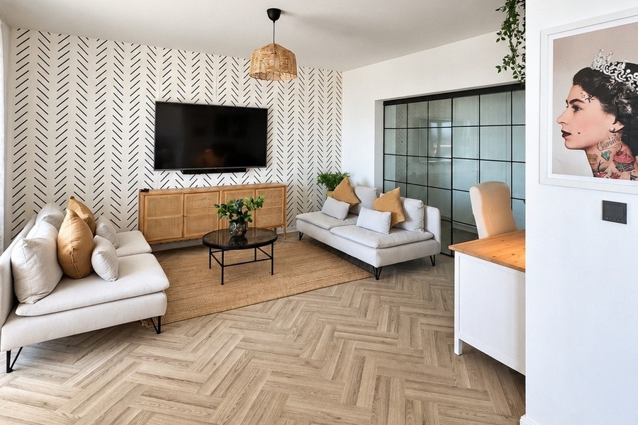 Salon avec canapé, téléviseur et parquet en point de Hongrie