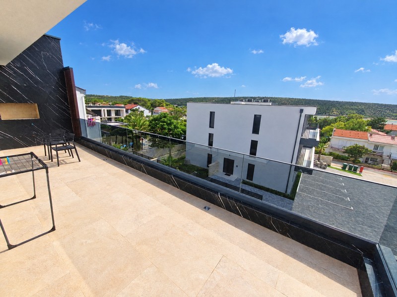 Terrasse avec vue sur la maison voisine et la baie