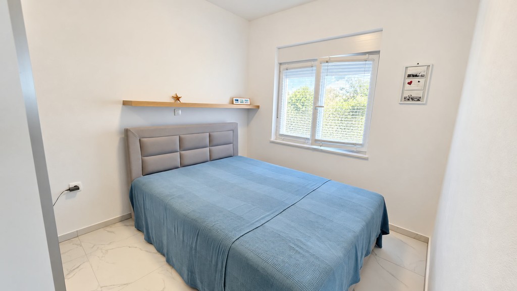 Chambre avec étagère murale et fenêtre