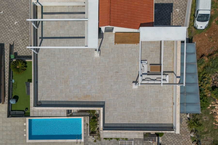 Vue aérienne avec terrasse sur le toit, pelouse et piscine