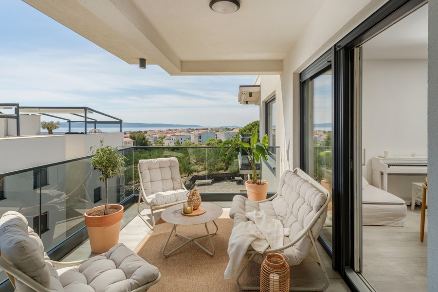 Terrasse couverte avec fauteuils et vue sur la mer