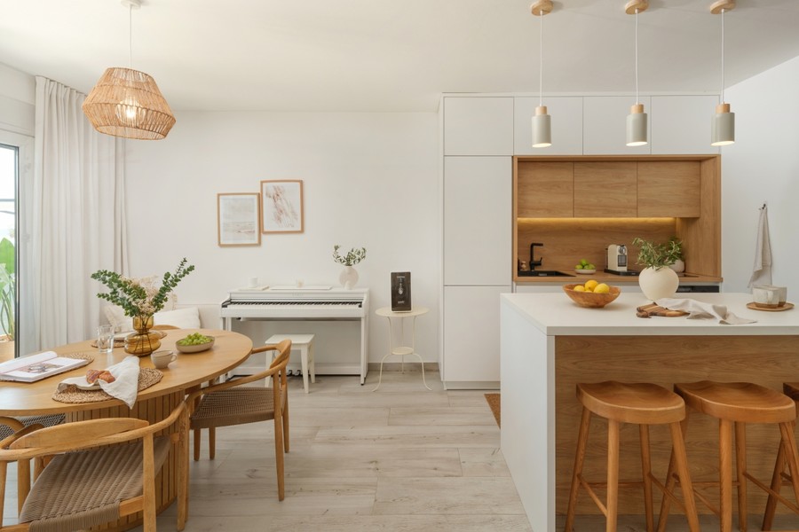 Coin repas avec table en bois et îlot de cuisine