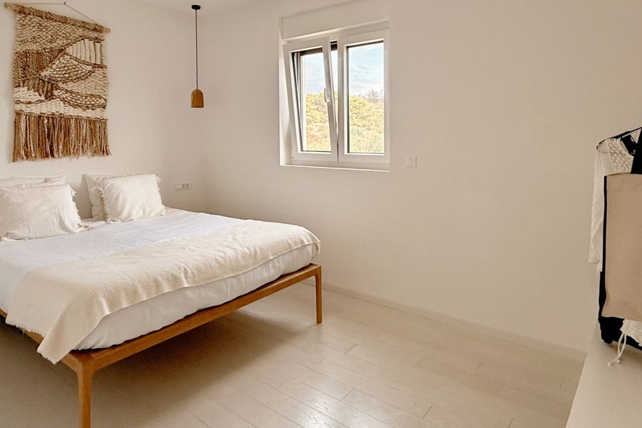 Deuxième chambre avec lit en bois et fenêtre