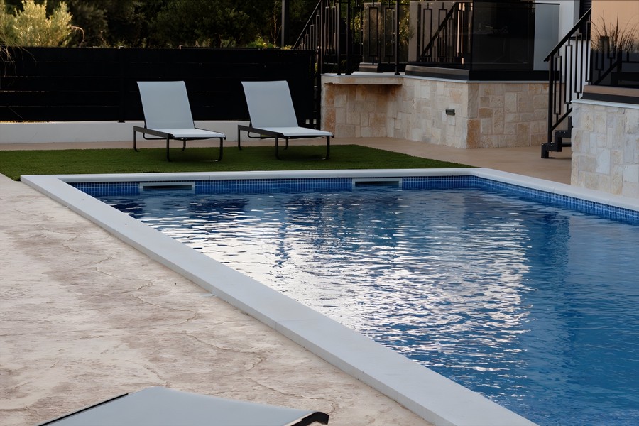 Piscine avec pelouse et chaises longues