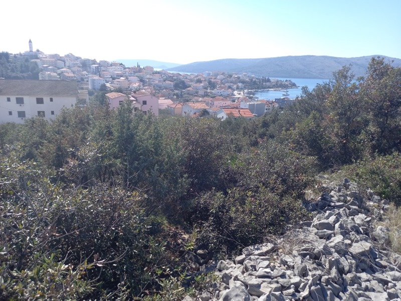 Broussailles avec vue sur le village, le clocher et la mer