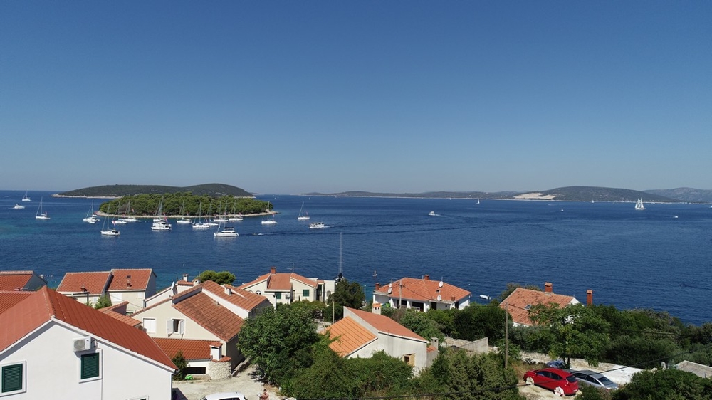 Toits de tuiles et baie avec voiliers à l'ancre