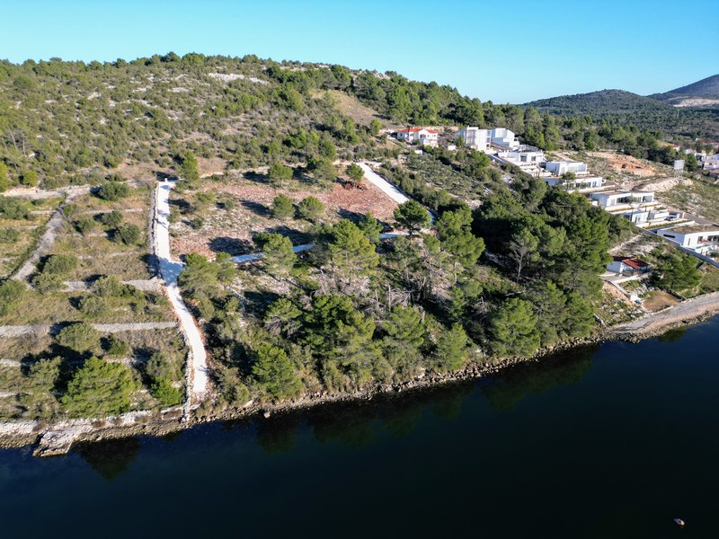 Vue aérienne de la rive boisée avec constructions neuves à flanc de colline