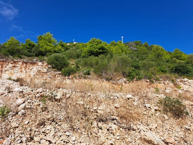 Terrain rocailleux avec maquis sous un ciel bleu