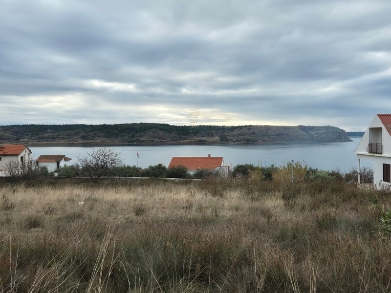 Herbe sèche avec vue sur la baie sous des nuages gris