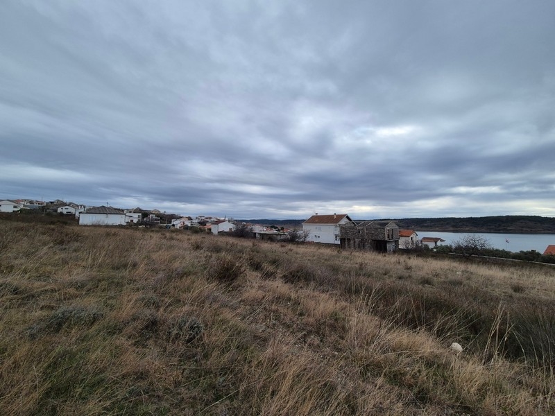 Pente avec vue sur le village et la baie par ciel couvert