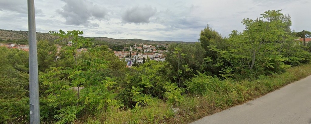 Terrain végétalisé au bord de la route avec vue sur le village