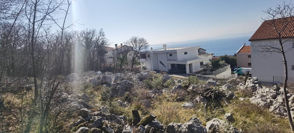 Terrain constructible rocheux avec vue sur la maison voisine et la mer