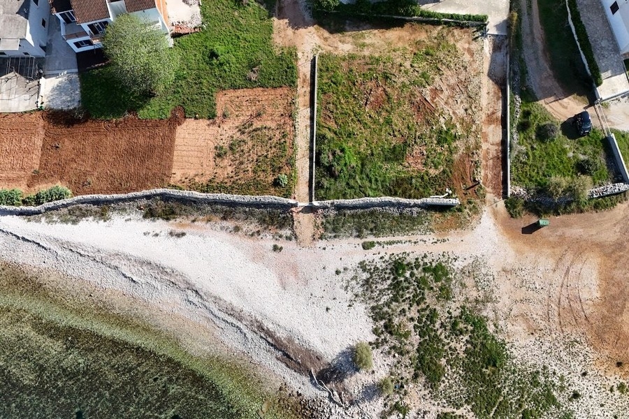 Vue aérienne des parcelles sur la plage de galets avec murs en pierre sèche