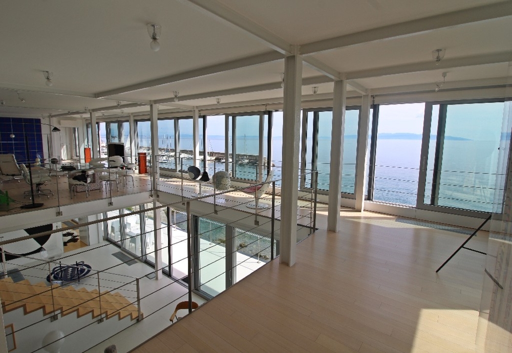Intérieur avec vue sur la mer et la piscine.