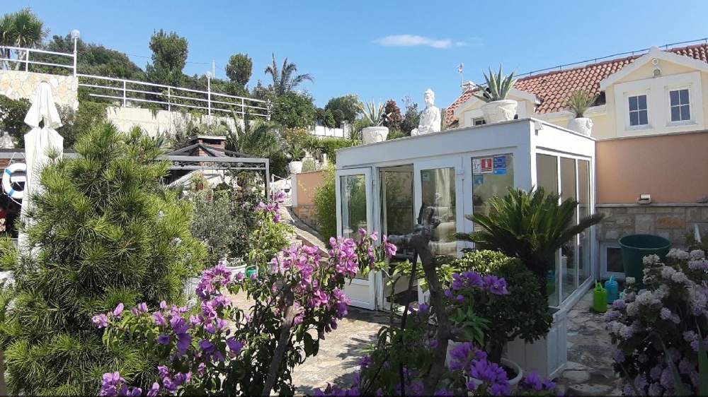 Vue depuis le jardin sur un espace extérieur couvert de la villa en Dalmatie centrale.