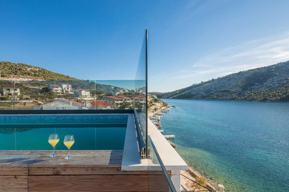 Verres au bord de la piscine avec vue sur le canal jusqu'à la pente