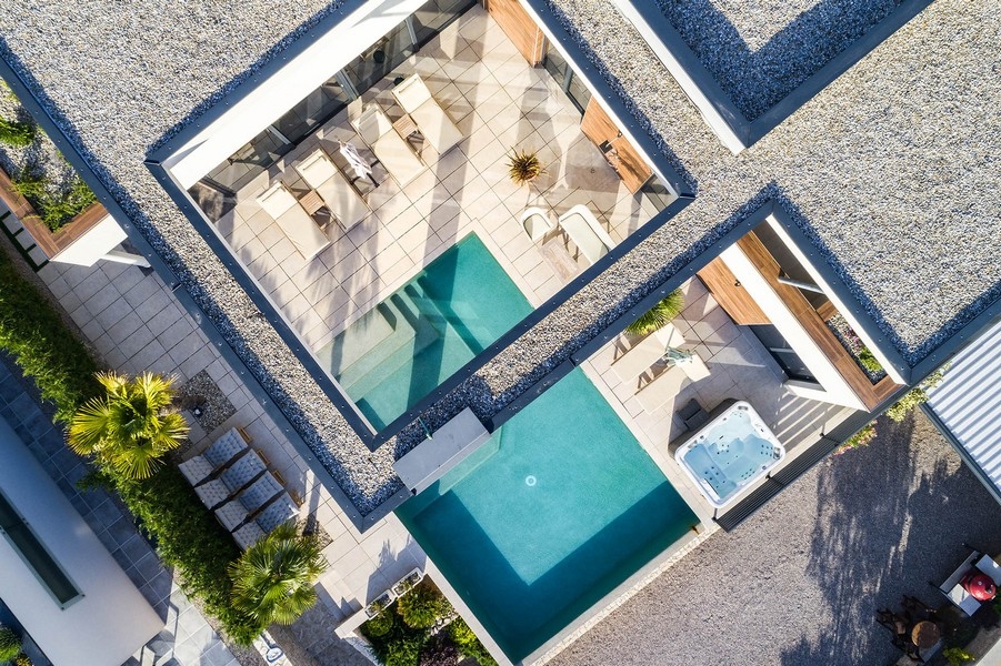 Vue aérienne de la piscine et du jacuzzi entre les ailes du bâtiment