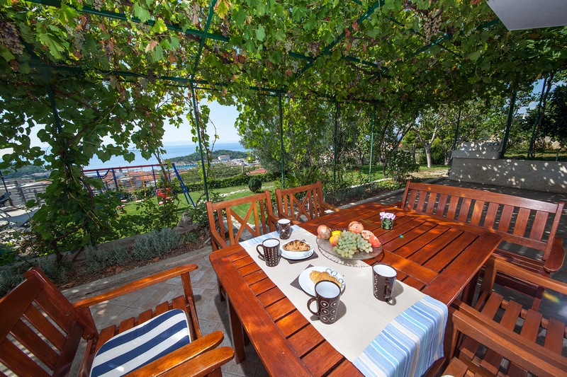Terrasse ombragée avec coin repas dans le jardin de la villa.