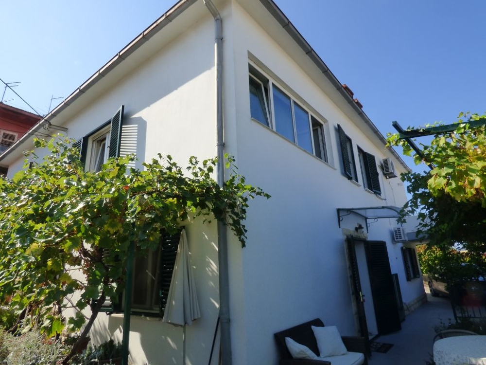 Angle de la maison avec vigne et banc à l'entrée