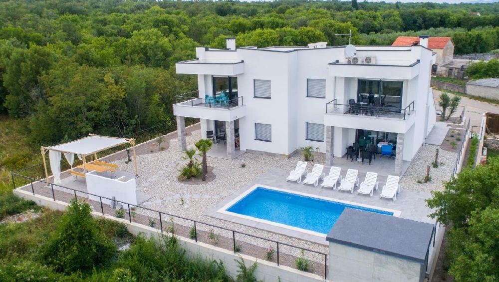 Vue aérienne de la villa avec piscine et pergola dans la verdure