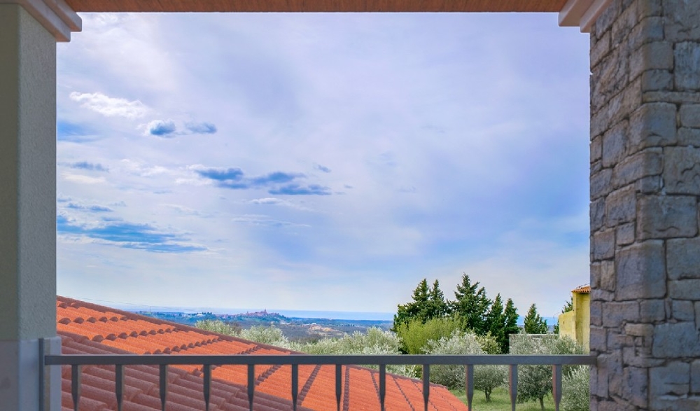 Vue depuis la loggia sur les toits en tuiles et les oliviers