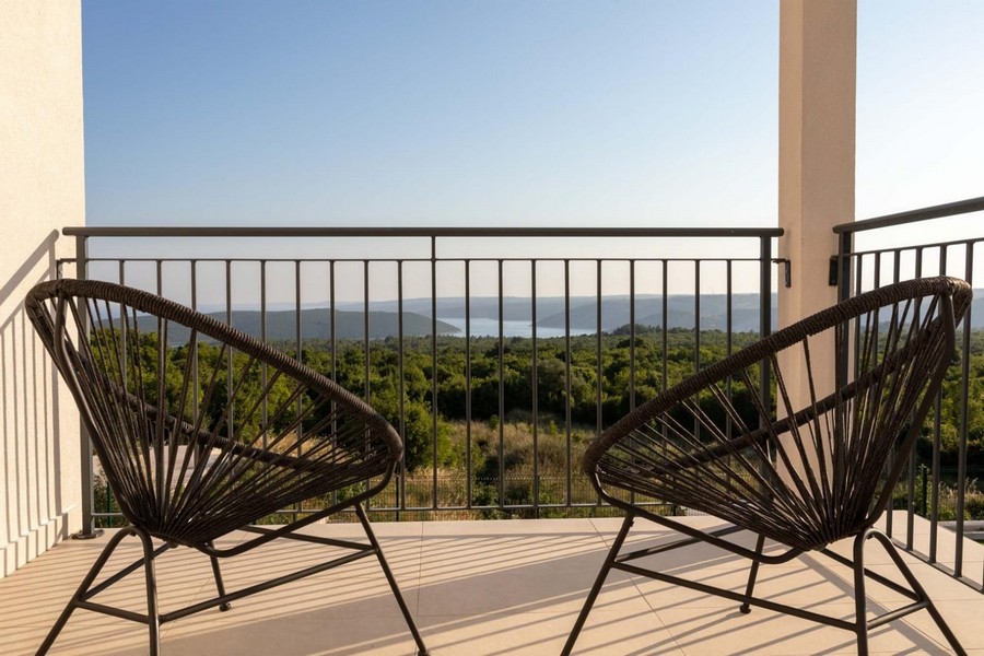Balcon avec fauteuils en fil métallique et vaste vue sur la brousse