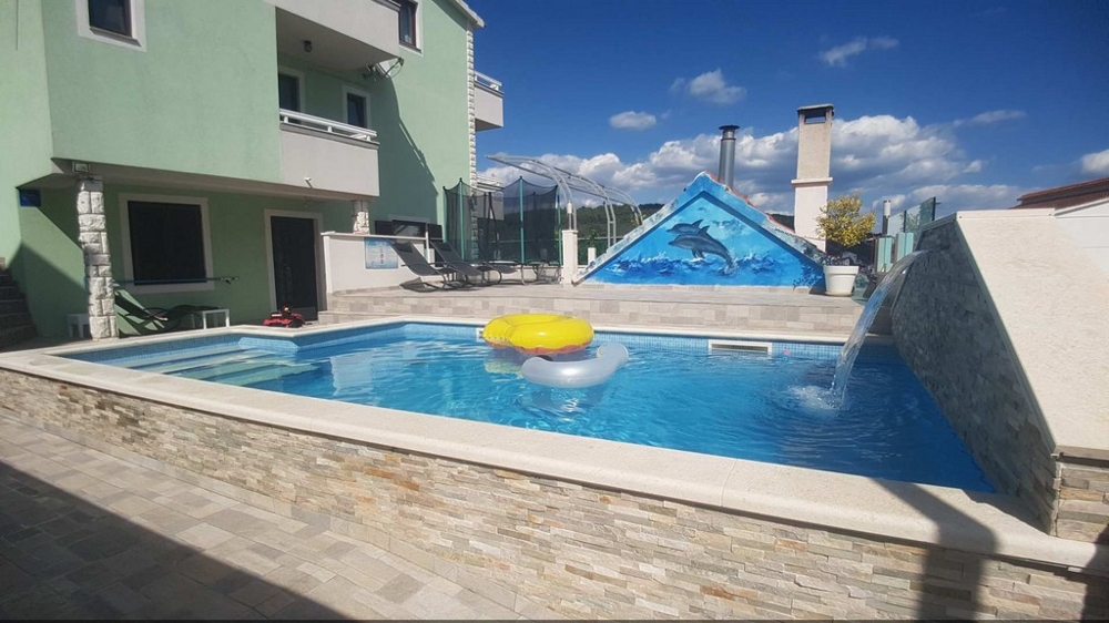 Vue depuis l'espace détente sur la piscine et l'arrière de la maison