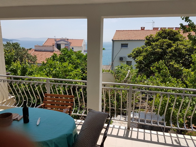 Vue sur le coin salon de la terrasse dans le jardin avec vue sur la maison