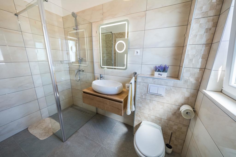 Une salle de bains avec douche à l'italienne et WC du bien H1467.