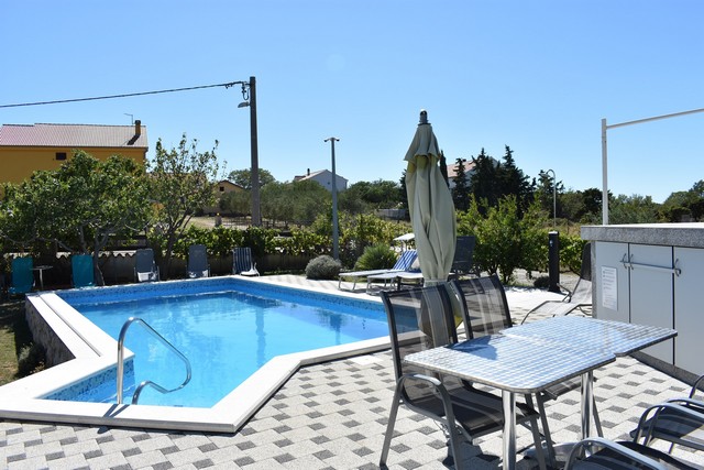 Vue depuis l'espace détente sur la piscine et le jardin en Croatie.