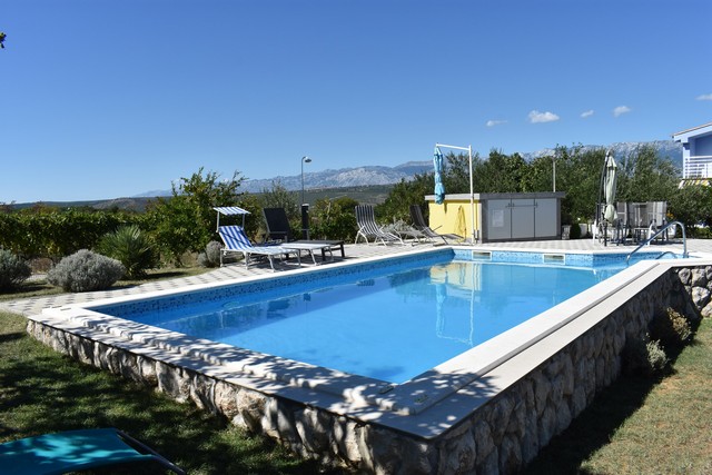 Vue depuis le jardin sur la piscine et les environs du bien H1525 en Croatie.