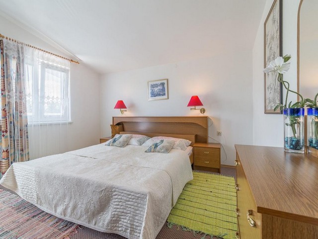 Une chambre lumineuse avec lit double et fenêtre dans la région de Zadar.