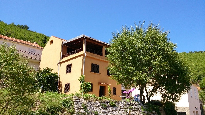 Vue sur l'arrière de la maison avec le grand balcon couvert - maison en pierre à vendre en Croatie.