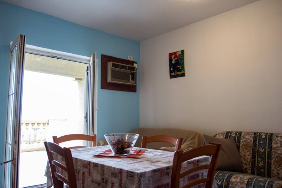 Un coin repas et séjour d'un appartement avec sortie sur le balcon - maison à vendre en Croatie.