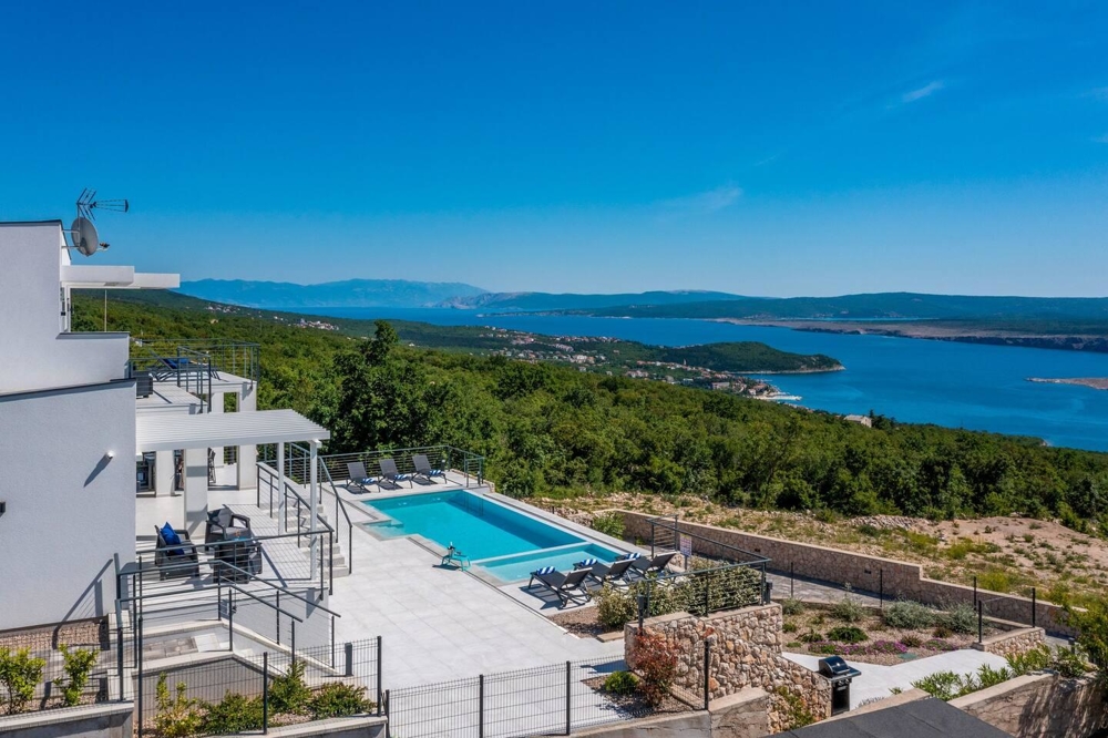 Piscine avec bains de soleil et vue dégagée sur le maquis et la baie