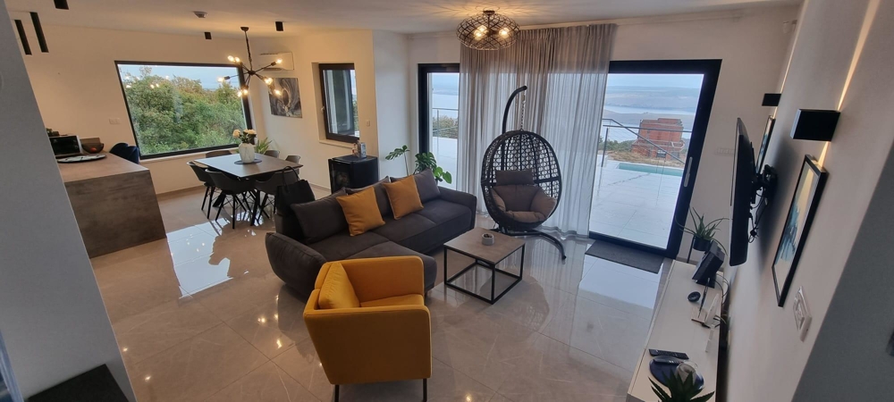 Séjour ouvert avec fauteuil suspendu et vue sur la mer