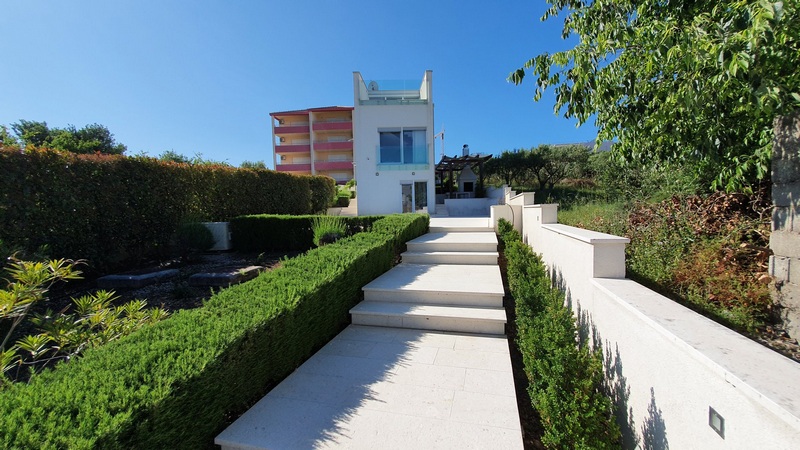 Chemin en escalier entre des haies taillées menant à la maison