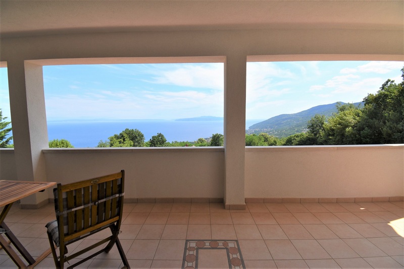 Loggia avec ouvertures dans le mur et vue sur la mer et les collines