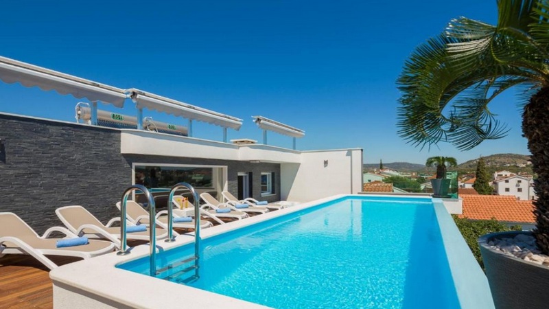 Piscine à débordement avec vue mer et solarium de la villa de luxe