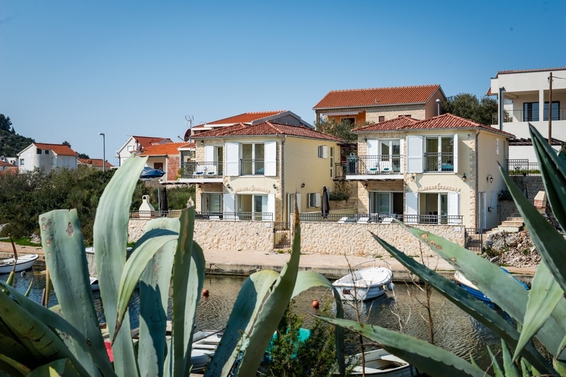 Maisons au bord du canal avec bateaux et agave au premier plan