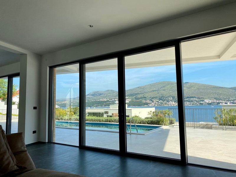Portes coulissantes avec vue sur la piscine, la baie et les montagnes